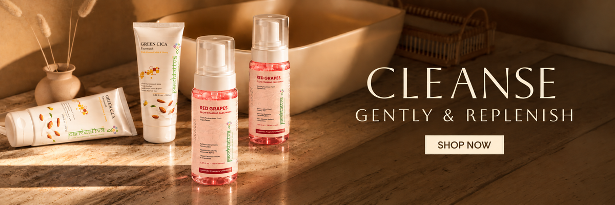 Four skincare products from The Art of Living are arranged on a wooden surface next to a beige stone tub in warm, sunlit tones. The products include a tube, a pump bottle, and two frosted bottles with pink and white labels.